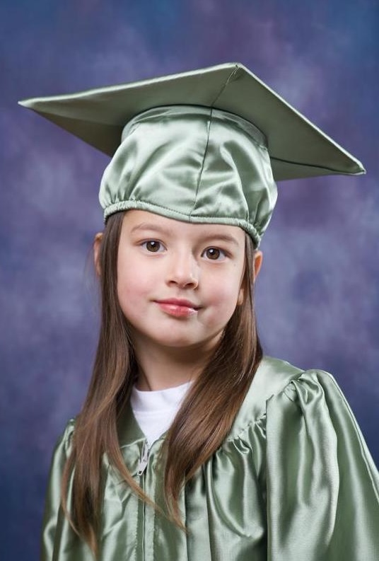 Student graduation portrait in a sage green cap and gown